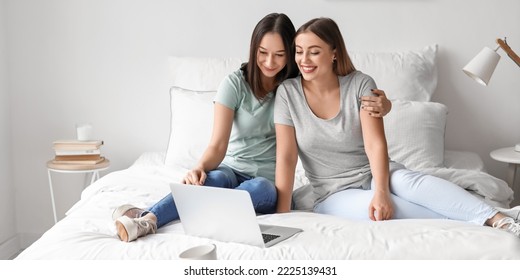 Young Lesbian Couple With Laptop In Bedroom