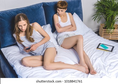 Young Lesbian Couple Lying In Bed After Argument