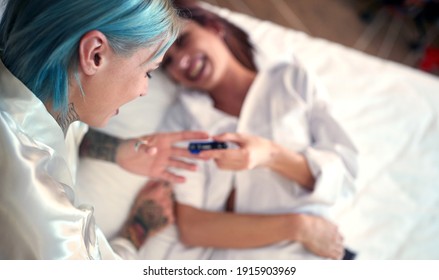 A Young Lesbian Couple Lying In A Relaxed Atmosphere In The Bed Is Happy About Positive Pregnancy Test. Love, Pregnancy, Lgbt, Relationship