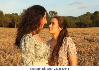 Young Lesbian Couple Portrait Looking At Each Other On A Field