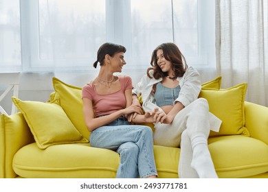 A young lesbian couple shares a tender moment on a sunny morning, their hands intertwined as they gaze into each others eyes. - Powered by Shutterstock