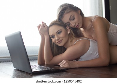 Young Lesbian Domestic Couple On Floor At Laptop, Put Heads Together