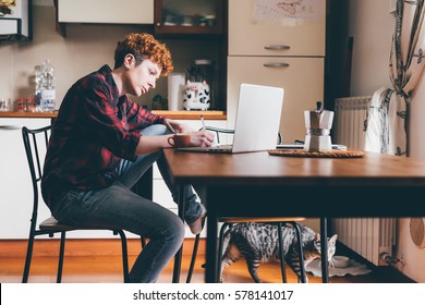 Young Lesbian Woman Sitting At Desk With Pen Hand Hold Using Computer Studying - Student, Technology, Working Concept