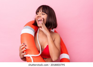 Young Life Guard Mixed Race Woman Isolated On Pink Background Shouting And Holding Palm Near Opened Mouth.