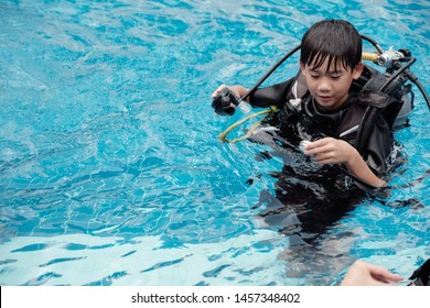 Young Little Asian Boy Scuba Diver Beginner Checking Pressure Gauge And Holding Regulator, Diving Lessons For Beginners, Preteen Teen Travel