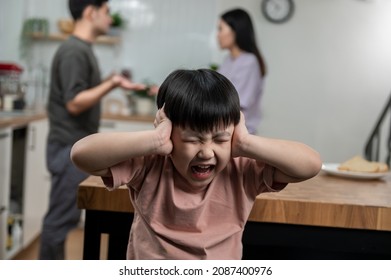 Young little Asian kid feel sad upset, boring while parent fighting arguing or quarrel, sad little boy frustrated with psychological problem caused by mom and dad family conflicts or violence concept.