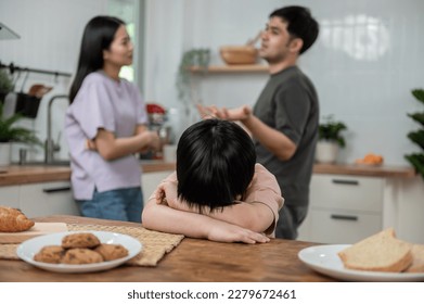 Young little Asian kid feel sad upset, boring while parent fighting arguing or quarrel, sad little boy frustrated with psychological problem caused by mom and dad family conflicts or violence concept. - Powered by Shutterstock