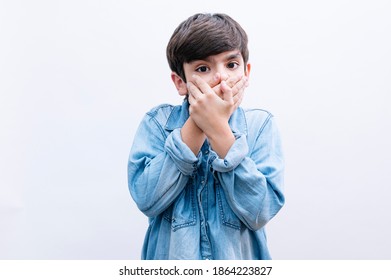 Young little boy kid cover mouth with hand shocked with shame for mistake, expression of fear, scared in silence, secret concept