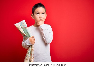 Young Little Boy Kid Looking At Turist City Destination Map Over Red Isolated Background Serious Face Thinking About Question, Very Confused Idea