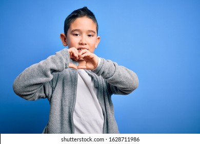 Young Little Boy Kid Wearing Sport Sweatshirt Over Blue Isolated Background Smiling In Love Showing Heart Symbol And Shape With Hands. Romantic Concept.