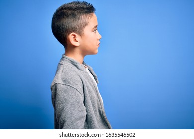 Young Little Boy Kid Wearing Sport Sweatshirt Over Blue Isolated Background Looking To Side, Relax Profile Pose With Natural Face With Confident Smile.