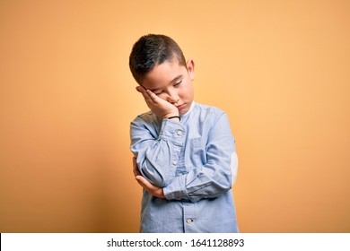 Young little boy kid wearing elegant shirt standing over yellow isolated background thinking looking tired and bored with depression problems with crossed arms. - Powered by Shutterstock