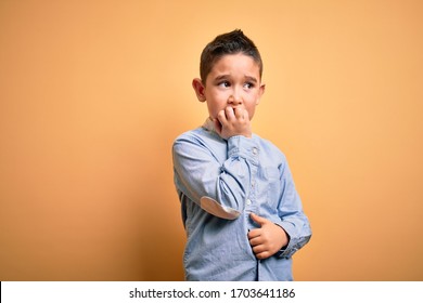 Young Little Boy Kid Wearing Elegant Shirt Standing Over Yellow Isolated Background Looking Stressed And Nervous With Hands On Mouth Biting Nails. Anxiety Problem.