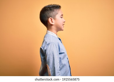 Young Little Boy Kid Wearing Elegant Shirt Standing Over Yellow Isolated Background Looking To Side, Relax Profile Pose With Natural Face With Confident Smile.