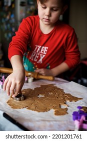 Young Little Caucasian Boy In The Christmas Pyjamas Making A Gingerbread Cookies In The Kitchen