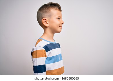 Young Little Caucasian Kid With Blue Eyes Standing Wearing Striped Shirt Over Isolated Background Looking To Side, Relax Profile Pose With Natural Face With Confident Smile.