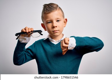 Young Little Caucasian Kid Holding Eyesight Glasses Correction Over Isolated Background With Angry Face, Negative Sign Showing Dislike With Thumbs Down, Rejection Concept