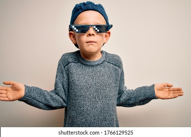 Young Little Caucasian Kid Wearing Internet Meme Thug Life Glasses Over Isolated Background Clueless And Confused Expression With Arms And Hands Raised. Doubt Concept.