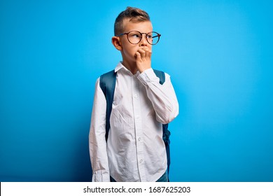 Young Little Caucasian Student Kid Wearing Smart Glasses And School Bag Over Blue Background Looking Stressed And Nervous With Hands On Mouth Biting Nails. Anxiety Problem.