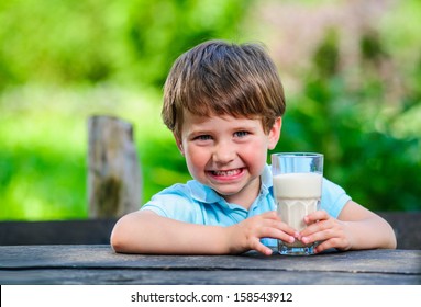 Young little and cute boy pictured with glass of milk. - Powered by Shutterstock