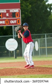 Young Little League Baseball Pitcher About The Pitch The Ball To Batter.