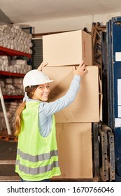 Young Logistics Woman As Warehouse Worker Trainee Stacks Packages In Delivery Service