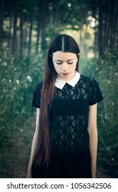 Young Lolita Girl In The Forest In Fairytale Mood - Wednesday Addams Style - Portrait Of A Young Woman In A Gloomy, Enigmatic Mood