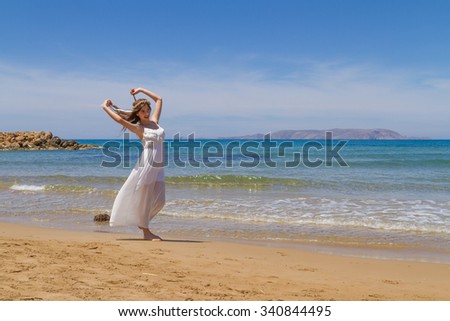 Young long haired brunette girl, pure angelic innocence in white flimsy dress, enjoying the sun on a fresh spring day.