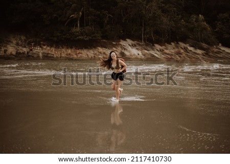 young long-haired girl bouncing along the beach