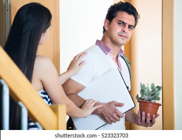 Young Longhaired Woman At The Doorway Watching Husband Leaving Her 
