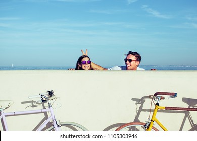 Young Lovely Couple Riding Vintage Bicycles Making Jokes and Having a Laugh Together. Best Friends Enjoying the Moment and Taking a Break After a Nice Bike Tour at Beach. Active Relationship Goals. - Powered by Shutterstock