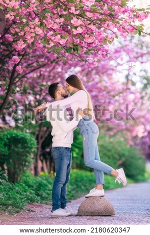 Young lovely couple walking in spring park. ravel in the spring to Japan. Pink color concept sakura