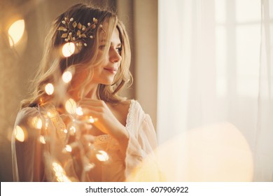 Young lovely housewife with a garland. Girl in sexy gown. Good morning. Dreamy face. Soft focus. Toning.