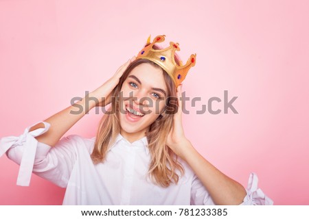 Young lovely woman in crown on pink background 