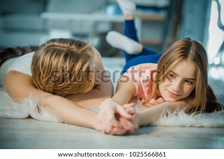 Young lovers relaxing together by holding the hands. A boy is passionately looking at his lady love.