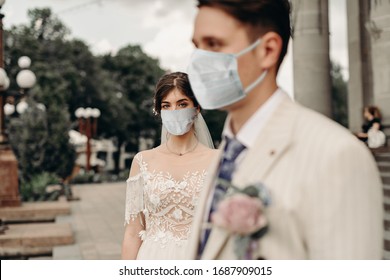 Young Loving Brides Walking In The City In Medical Masks During Quarantine On Their Wedding Day. Coronavirus, Disease, Protection, Sick, Illness