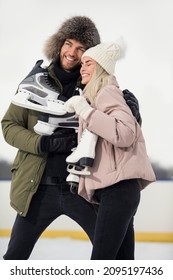 Young Loving Caucasian Couple On Skatingrink With Ice Skates Posing Together Over a Snowy Winter Landscape Outdoor. Vertical image Composition - Shutterstock ID 2095197436