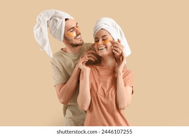 Young loving couple after shower with under-eye patches on beige background - Powered by Shutterstock