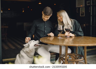 Young Loving Couple Enjoying With A Dog In A Cafe