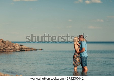 The young loving couple kissing in the sea