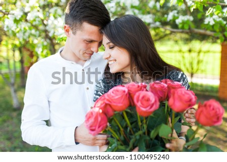 young loving couple in love, girl holding flowers, happy and enjoy the beautiful nature, advertising,