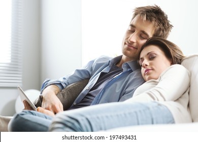 Young loving couple sleeping on sofa in the living room.