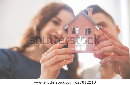 Young loving couple with small wooden house new home concept