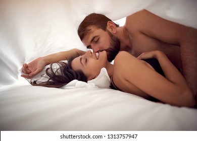 Young loving man and woman making love in bed- Passionate sex