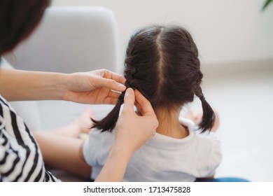 Young loving mother brushing kid daughters hair sitting on sofa, - Powered by Shutterstock