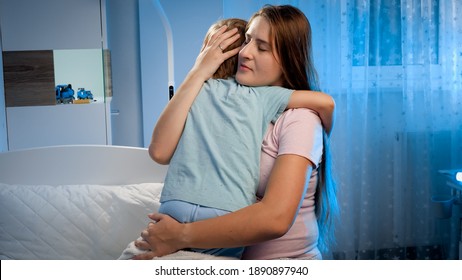 Young Loving Pregnant Mother Hugging And Talking To Her Sad And Scared Toddler Son Lying In Bed And Trying To Sleep At Night. Parent Soothing Child Having Nightmare Dream.