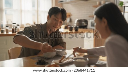 Young Loving South Korean Couple Eating Homemade Tasty Food at Home and Having a Fun Chat. Asian Boyfriend and Girlfriend Enjoying Time Together, Feasting on Cooked Fish, Spicy Vegetable Soup and Rice