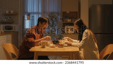 Young Loving South Korean Couple Eating Homemade Tasty Food at Home and Having a Fun Chat. Asian Boyfriend and Girlfriend Enjoying Time Together, Feasting on Cooked Meat, Spicy Vegetable Soup and Rice Foto d'archivio © 