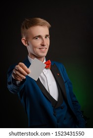 a young magician guy is holding cards in his hands