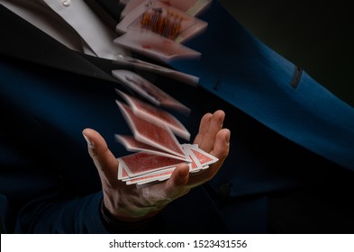 a young magician guy is holding cards in his hands